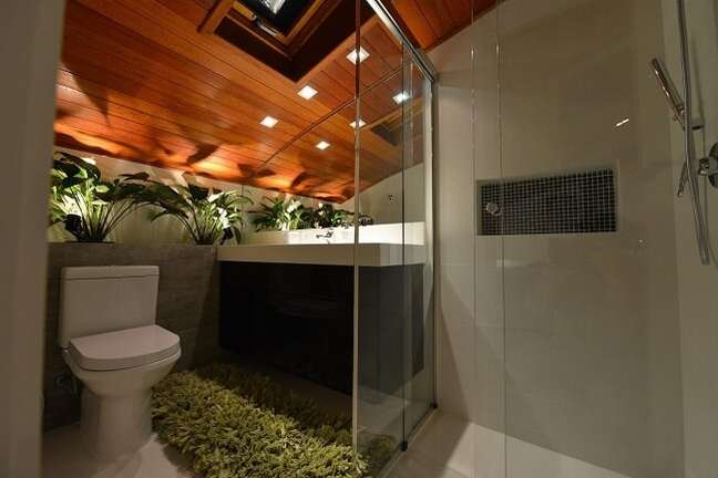 59. Banheiro feminino aconchegante com plantas e tapete verde. Fonte: Anna Maya Arquitetura