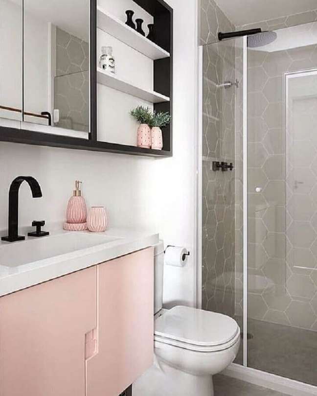 18. Decoração para banheiro feminino com gabinete rosa, nicho preto e revestimento cinza com formato hexagonal na área do box – Foto: Wattpad