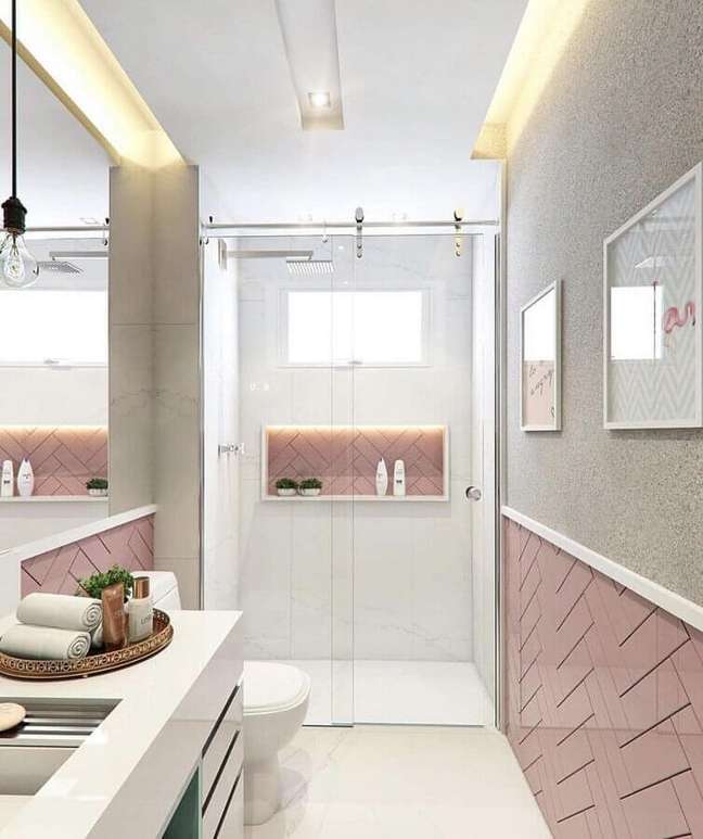 23. Banheiro feminino pequeno decorado com iluminação embutida e revestimento rosa – Foto: Arkpad