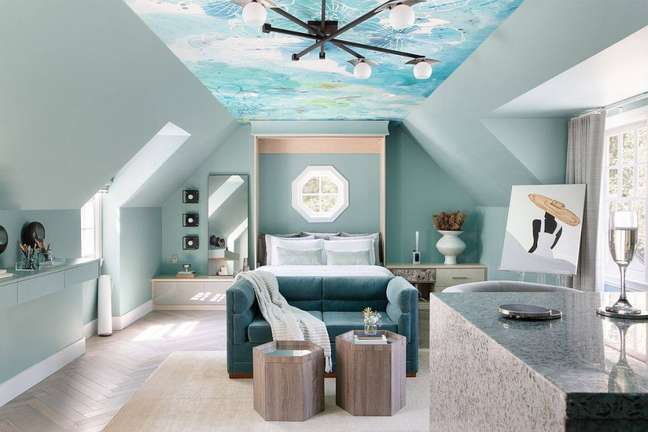 Quarto com paredes pintadas de azul clarinho e teto com pintura que alude a nuvens.