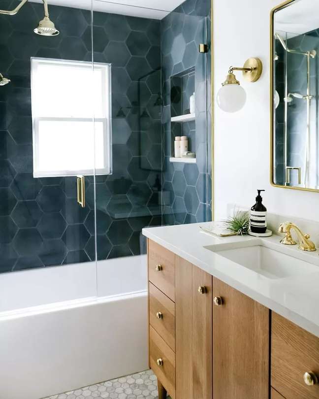 These dramatic aquamarine hex tiles from Jessica Nelson Interior Design bring out the strong airs of marine charm in the best possible way. Rich, colorful tiles are a great addition to any sleek bathroom, but be sure to keep the rest of the space neutral enough for them to take center stage. Here the tiles are combined with natural wood that does not contrast with the strong colors of the shower. These dramatic aquamarine hex tiles from Jessica Nelson Interior Design bring out the strong airs of marine charm in the best possible way. Rich, colorful tiles are a great addition to any sleek bathroom, but be sure to keep the rest of the space neutral enough for them to take center stage. Here the tiles are combined with natural wood that does not contrast with the strong colors of the shower.