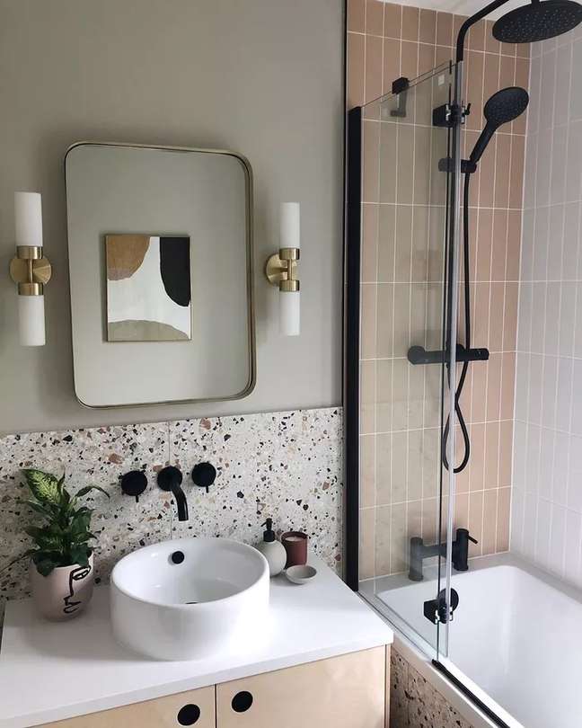 This bathroom by formandbalance features a salmon-colored subway tile that complements the beautiful terrazzo tile on the wall.  The terrace is making a big comeback, it adds a lot of visual interest and is easy to clean because it camouflages stains.