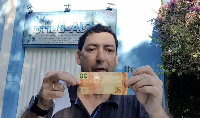 Paulo Vinícius Coelho com sua nota de R$ 20 recuperada.