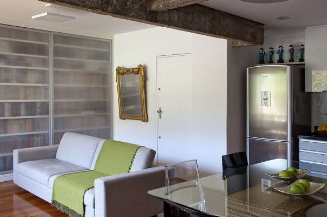 70. Apartamento pequeno com sofá cinza com manta verde – Foto Archdaily