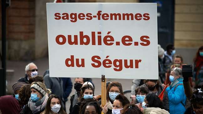 Na França, pessoas usam pontos para a linguagem inclusiva, como é possível ver no cartaz do protesto