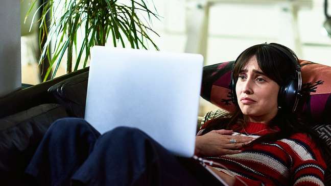 Young woman excited while watching a movie in notebook Young woman excited while watching a movie in notebook