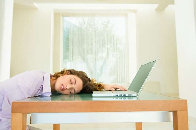 Exhausted woman in front of notebook Exhausted woman in front of notebook