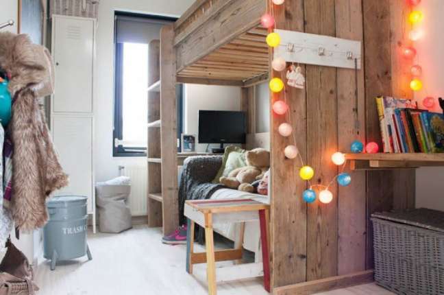 Bedroom with wooden bunk bed decorated with colored lights. Bedroom with wooden bunk bed decorated with colored lights.