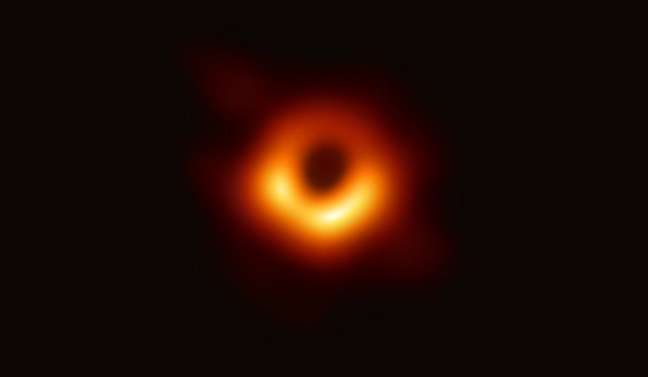 Buraco negro que fica no centro da galáxia M87 e o anel brilhante formado à medida que a luz se dobra na gravidade intensa ao redor do buraco negro (Foto: EHT)