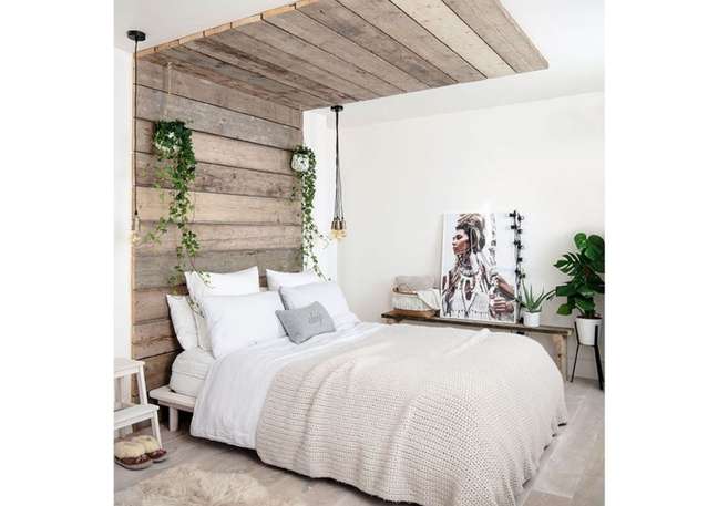 Swap a standard-style headboard with a recycled design made with reclaimed wood paneling on the wall and ceiling, above and behind the bed.