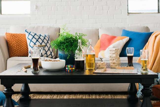 Give guests a way to break the ice when sitting around the coffee table. Some fun options to consider: a board game, deck of cards, or dominoes to add some whimsy to the space Give guests a way to break the ice when sitting around the coffee table. Some fun options to consider: a board game, deck of cards, or dominoes to add some whimsy to the space