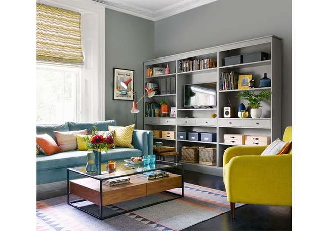 A shelving and cabinet unit that spans an entire living room wall will provide stacks of storage and free up more space than having multiple individual pieces scattered around the room.