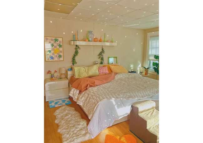 O quarto do Instagrammer Kailtin apresenta mini tapetes de todos os tamanhos, flores e uma mistura animada de tecidos rosa e laranja, tornando-o um local acolhedor para relaxar.