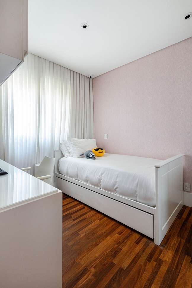14. O papel de parede rosa claro traz um toque delicado para o quarto de menina. Foto: Maura Mello