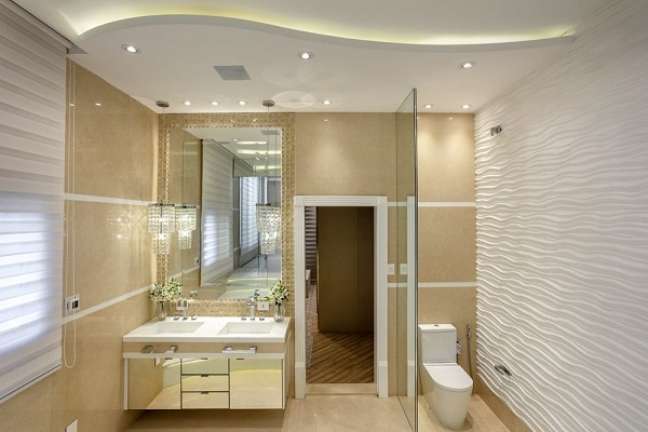 40. Banheiro bege e branco com armário espelhado – Foto Iara Kilaris