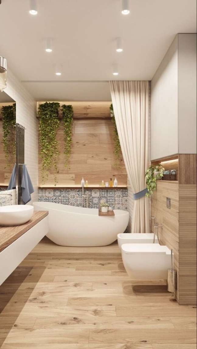 32. Banheiro bege com madeira e banheira branca – Foto Loft e Home
