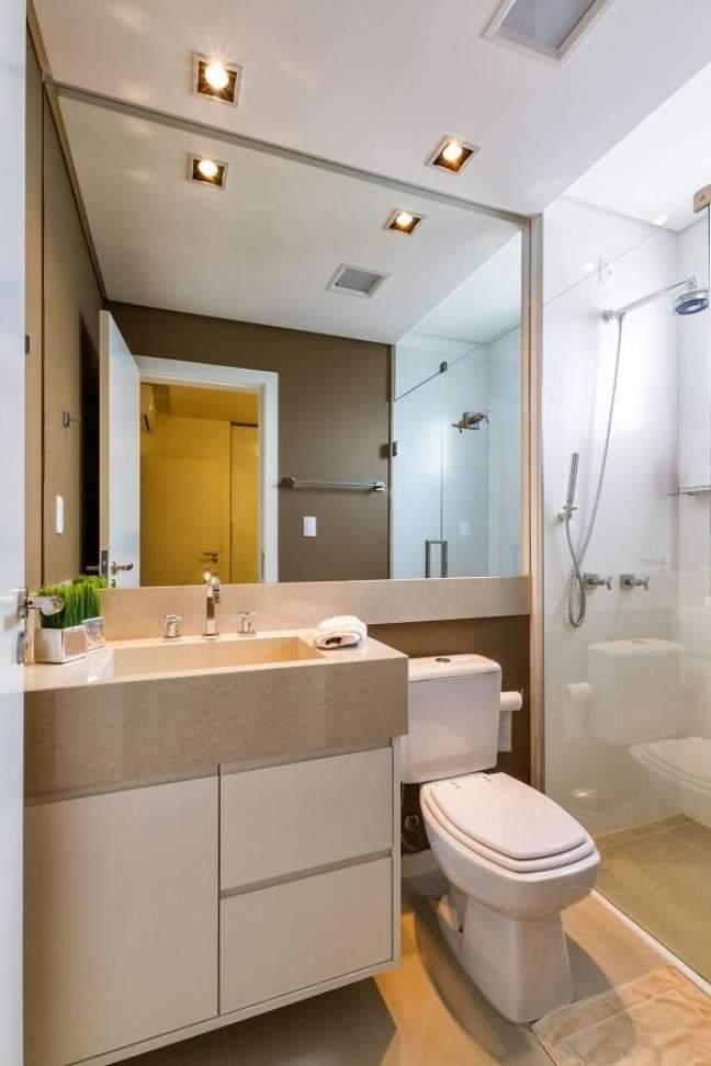 37. Banheiro bege com piso amadeirado espelho na parede – Foto Duo Traco