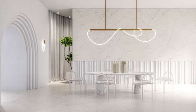 White dining table with white chairs in a minimalist setting with floors and walls covered in the same light porcelain stoneware reminiscent of marble. White dining table with white chairs in a minimalist setting with floors and walls covered in the same light porcelain stoneware reminiscent of marble.