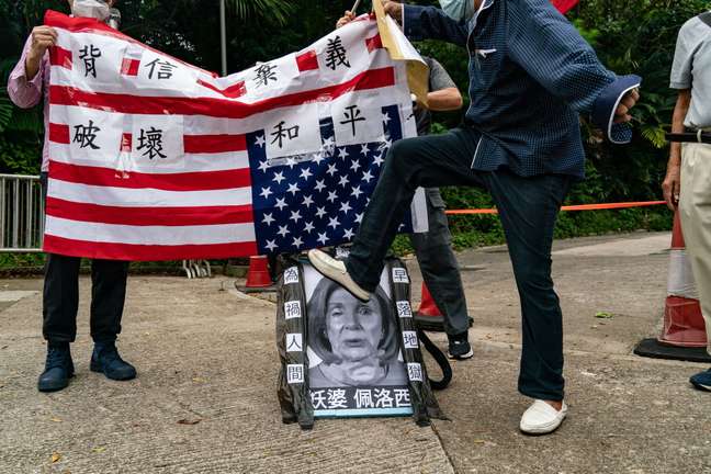 Um manifestante pró-China pisa na foto de Nancy Pelosi, parlamentar americana que visitou Taiwan acirrando as tensões com a China