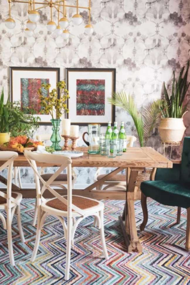Mix things up: For a modern bohemian look in your dining room, layer contrasting prints, vibrant colors, and plenty of texture.  A variety of seating options enhance the intentionally eclectic look, as does an abundance of green potted plants.
