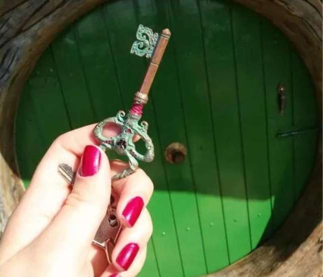 The front door is green and has a handle in the middle. The front door is green and has a handle in the middle.