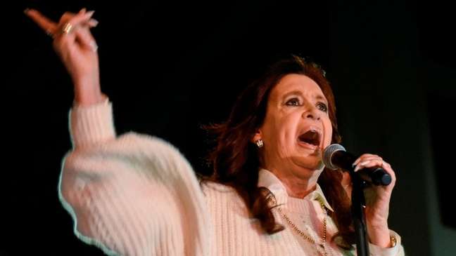 Kirchner gesticula enquanto fala no microfone, em evento à noite Kirchner gesticula enquanto fala no microfone, em evento à noite