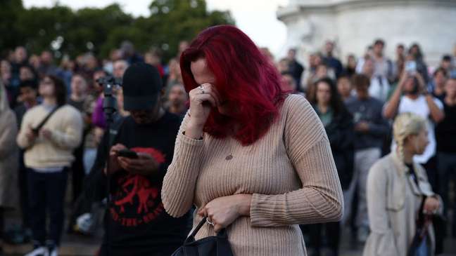 Mulher reage à notíicia da morte da rainha Elizabeth 2ª em frente ao palácio de Buckingham