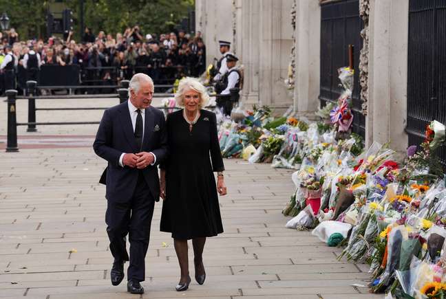 Rei Charles e Camilla Parker Bowles observam homenagens para a rainha Elizabeth em frente ao Palácio de Buckingham  