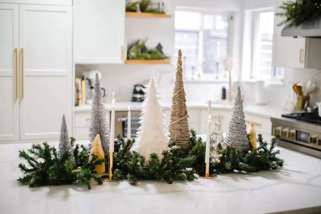 Do you have a large kitchen island that you rarely use? Decorate with a handful of small trees, like this variety of woven mini trees draped over a wire garland. Do you have a large kitchen island that you rarely use? Decorate with a handful of small trees, like this variety of woven mini trees draped over a wire garland.