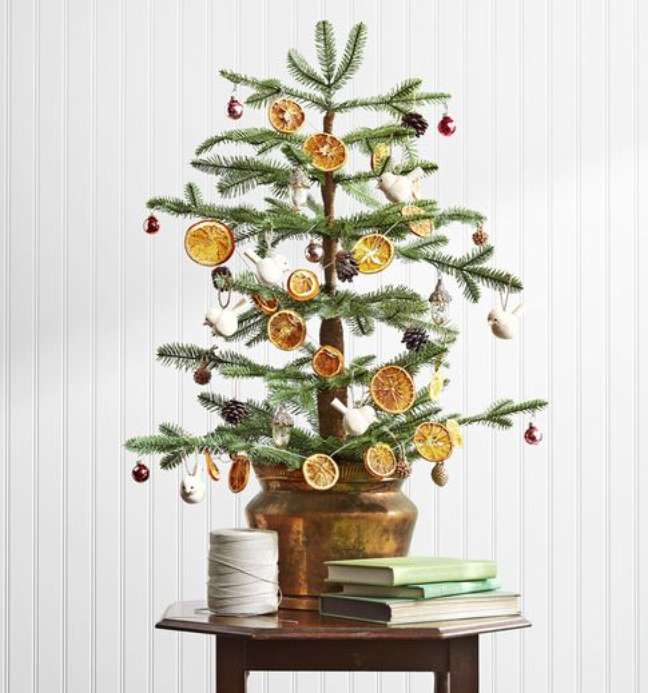 Less is more in this Christmas tree covered in pine and orange ornaments, which add an organic touch to the decor. Less is more in this Christmas tree covered in pine and orange ornaments, which add an organic touch to the decor.
