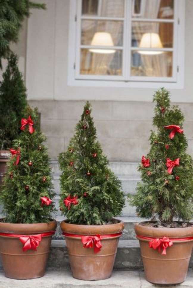 These mini potted Christmas trees are adorable. To achieve a similar effect, whether you place one in the living room or line a bunch on the porch, simply tie bows around the rim of the vase and add little embellishments. These mini potted Christmas trees are adorable. To achieve a similar effect, whether you place one in the living room or line a bunch on the porch, simply tie bows around the rim of the vase and add little embellishments.