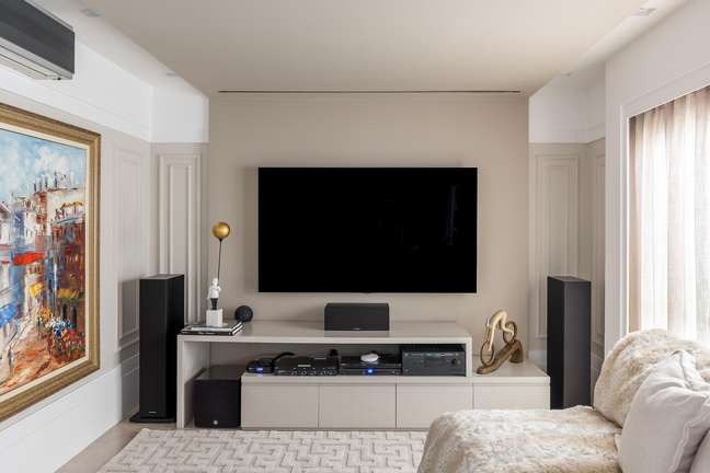 In this living room, due to the large quantity of electronics purchased by the family, Cristiane Schiavoni opted for the insertion of a large rack, which could hide all the cables and sockets, making the environment pleasant and harmonious.