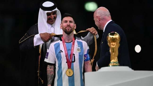 Messi recibe un puño de Amir antes de levantar el trofeo de la Copa del Mundo (Foto: Paul Ellis/AFP)