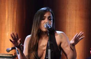 Anitta chama atenção com macacão superdecotado em show