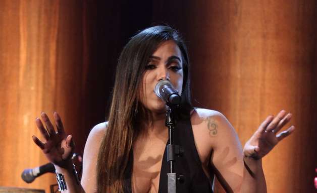 Anitta chama atenção com macacão superdecotado em show