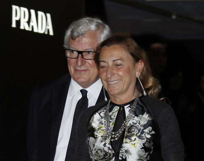 Miuccia Prada e seu marido, Patrizio Bertelli, são vistos em junho de 2011 ao passar pelo logotipo da empresa em Hong Kong, na China. A grife italiana Prada contrariou as preocupações sobre uma forte desaceleração nos gastos com bens de luxo ao apresentar um salto de 59,5 por cento no lucro líquido e afirmar que as vendas nos últimos dois meses ficaram em linha com as expectativas. 07/06/2011