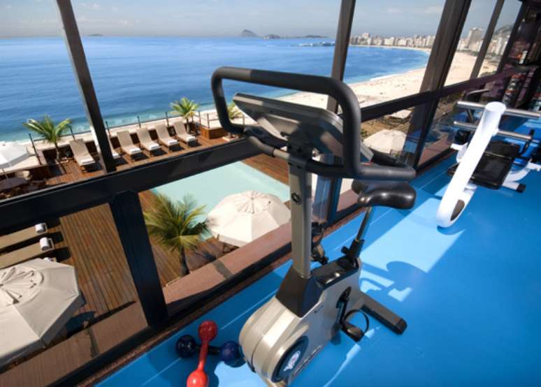 Porto Bay Rio Internacional Hotel, Rio de Janeiro - A academia está localizada no piso superior do hotel e possui um teto de vidro que permite uma vista panorâmica do oceano e das piscinas, além de muita luz natural. Está localizada em uma das mais famosas praias cariocas, Copacabana, que pode ser apreciada durante a malhação