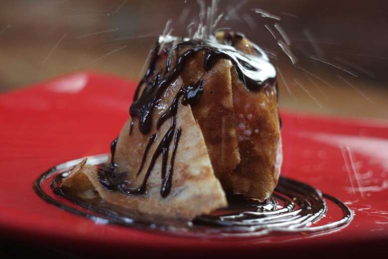 O crepe leva com sorvete de chocolate, calda de chocolate e redução de laranja, e é flambado com cointreau