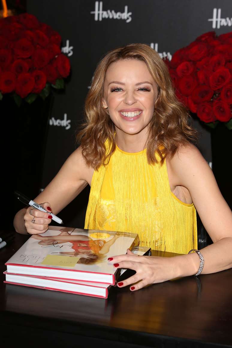 Kylie Minogue escolheu um look amarelo para o lançamento de seu livro