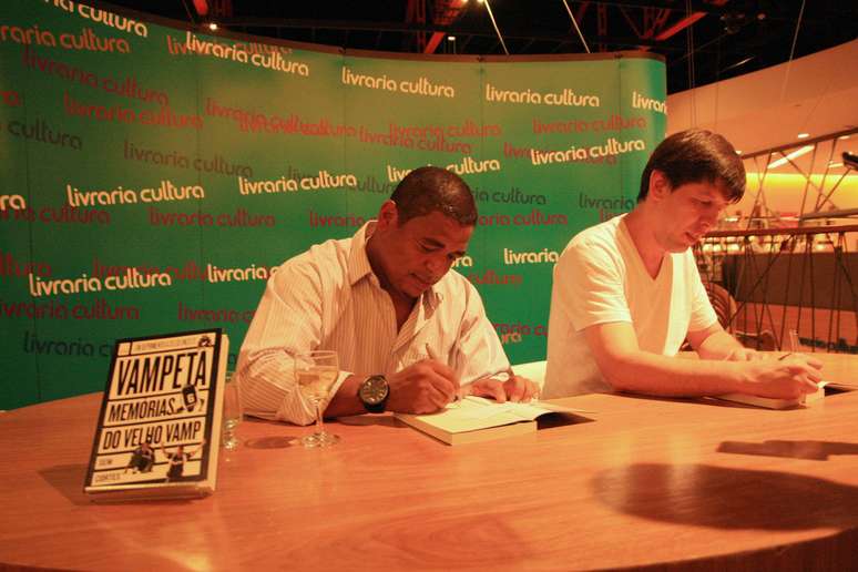 Vampeta e Celso Unzelte posam com livro