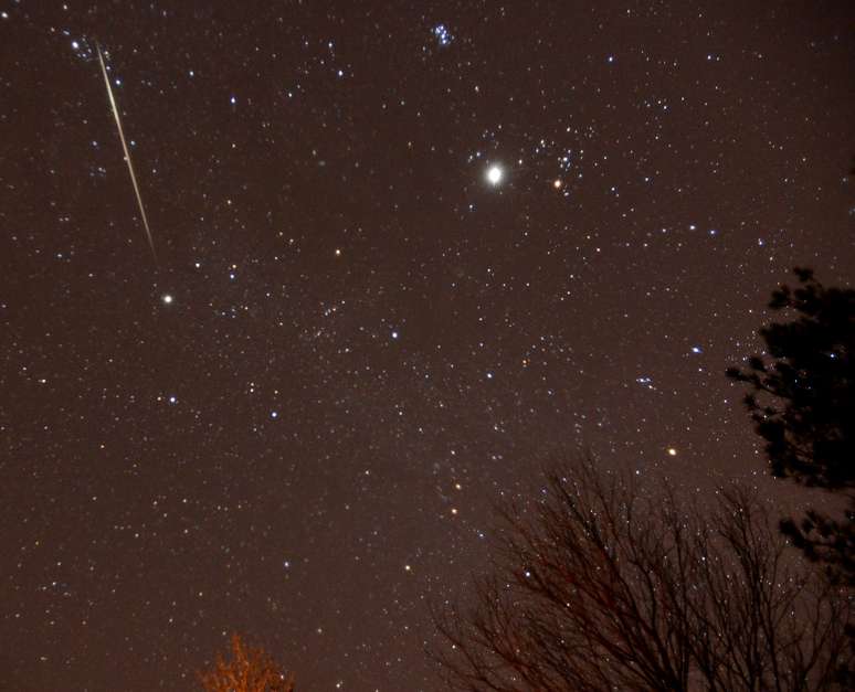 Um meteoro cruza o céu durante a chuva de meteoros anual Geminídeas sobre Springville, Alabama