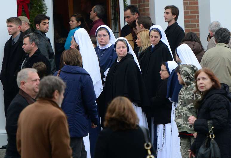 Freiras, fiéis e cidadãos chegam a missa na Igreja Sta. Rosa de Lima em Newtown, Connecticut