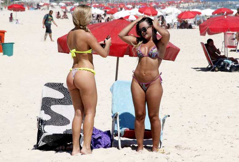 Em tarde ensolarada, com temperaturas que ultrapassaram os 30ºC, a apresentadora Caren Souza e a coelhinha da revista 'Playboy' Thais Schmitt aproveitaram para reforçar o bronzeado na praia da Barra da Tijuca, zona oeste do Rio de Janeiro. Ambas usavam biquínis fio-dental coloridos