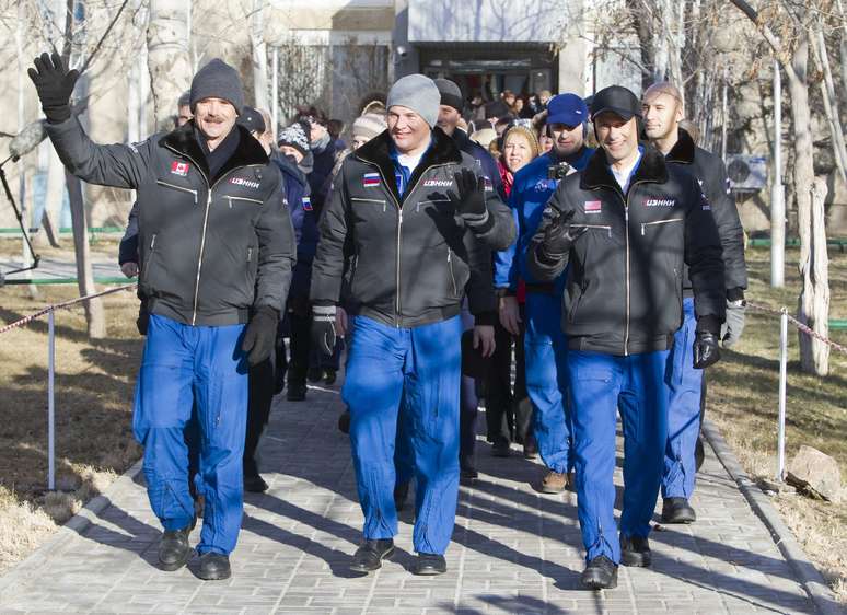 Membros da missão acenam ao deixar hotel rumo ao Cosmódromo de Baikonur