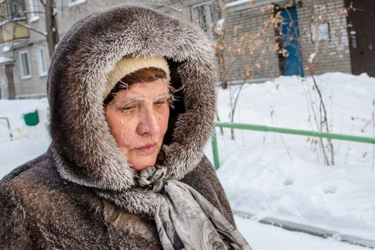 Mulher camninha pelas ruas da cidade siberiana de Novosibirsk; frio na Rússia chega a -50ºC