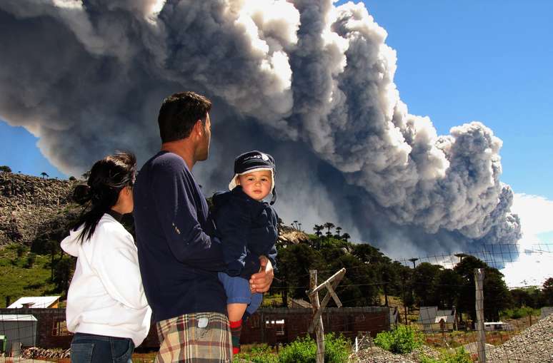 Família assista ao vulcão Copahue expelir suas cinzas em Caviahue, na Argentina