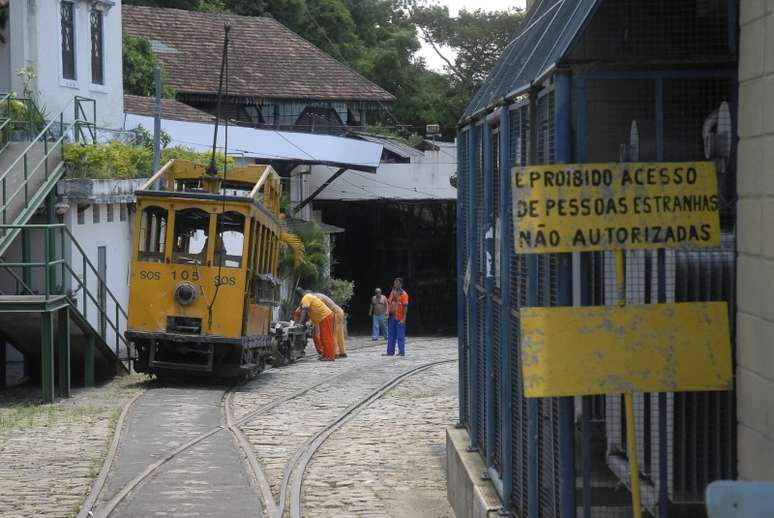 Empregados da empresa T-Trans retiram a carcaça de um bonde da oficina localizada em Santa Teresa