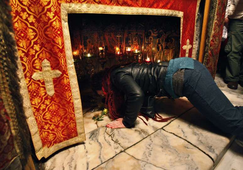 Cristã reza dentro de gruta na Basílica da Natividade, em Belém, na Cisjordânia