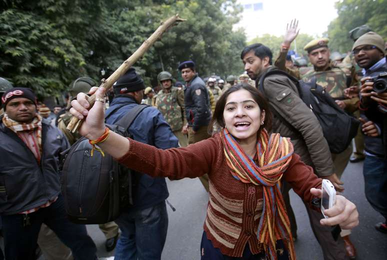 Manifestante segura bastão durante protesto em Nova Délhi, Índia