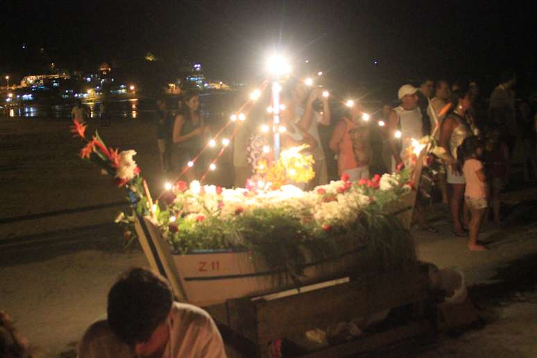 Ap&oacute;s acenderem velas pela areia e realizarem um ritual, o grupo levou oferendas e ao final lan&ccedil;ou um barco ao mar